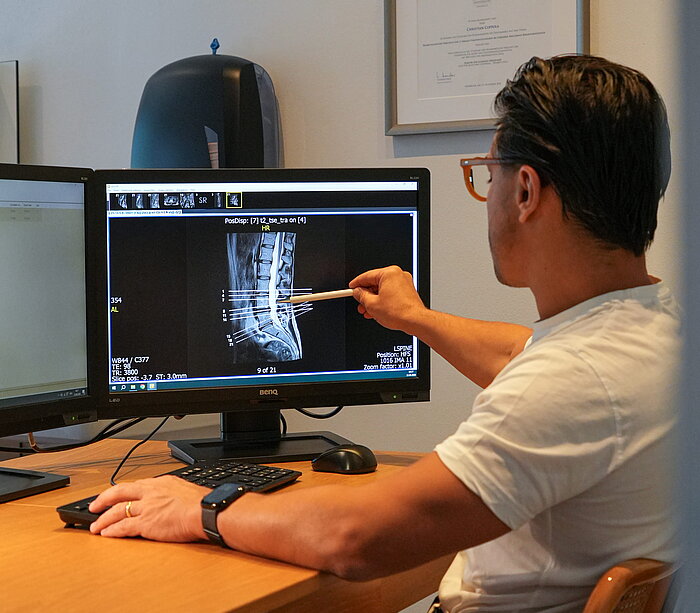 AGON | Physiotherapie, Training & Orthopädie in Sterzing Dr. Christian Coppola bei der Befundbesprechung einer MRT-Aufnahme